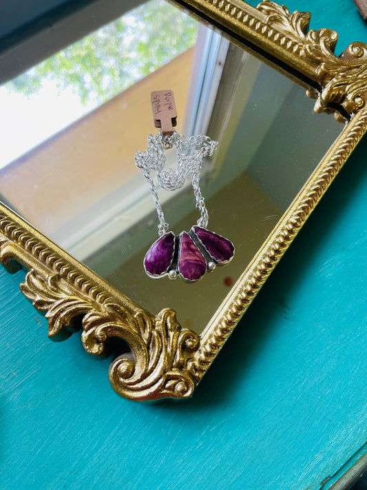 3 purple spiny oyster stones set in sterling silver on a sterling silver 18” chain resting on a gold mirror
