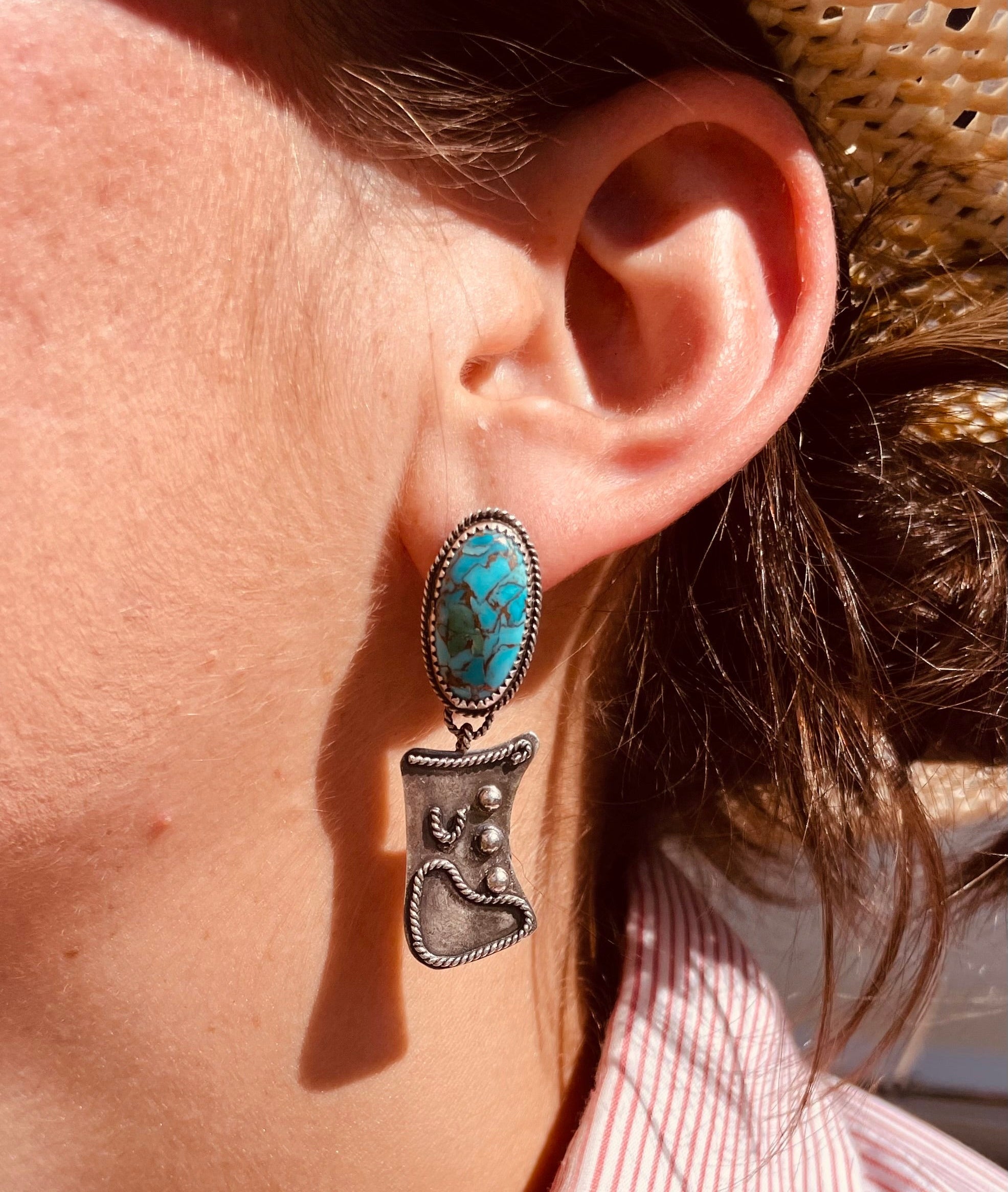Turquoise dangle earrings featuring a turuqoise stone with twist wire and the danlge a sterling silver cowboy chap