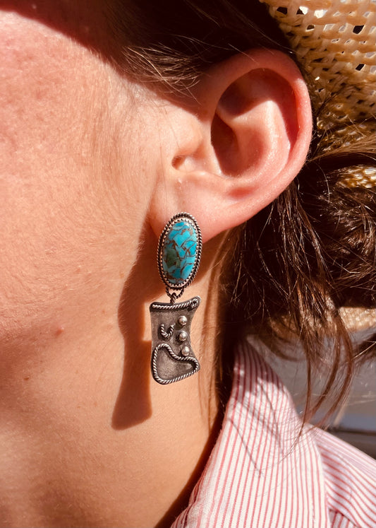 Turquoise dangle earrings featuring a turuqoise stone with twist wire and the danlge a sterling silver cowboy chap